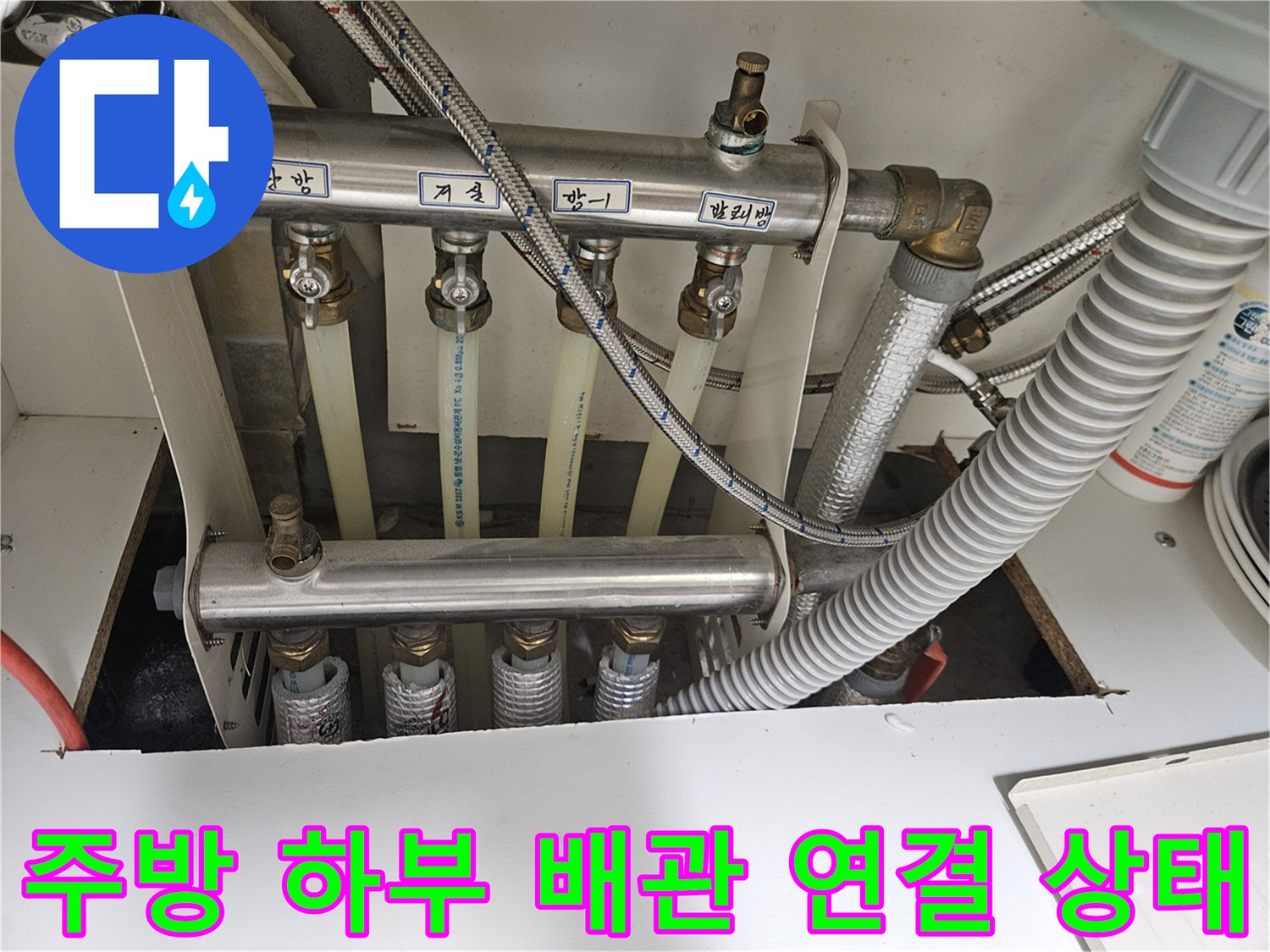 싱크대 아래쪽의 은색 배관과 흰색 호스 구조
