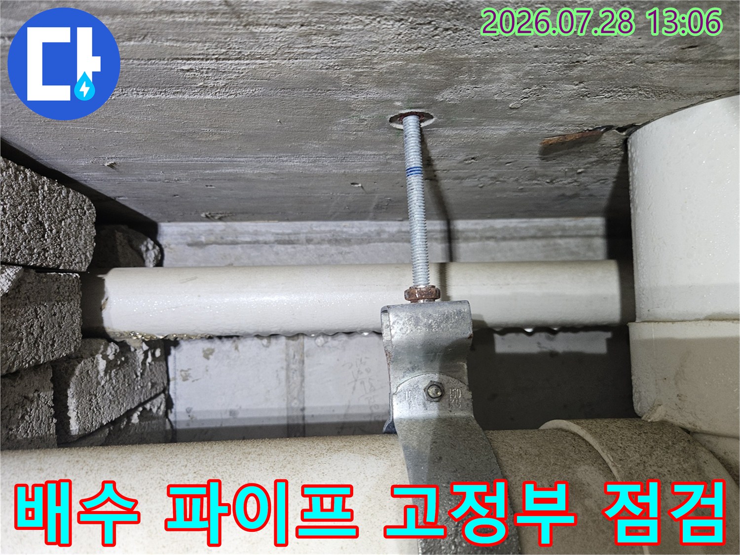 흰색 배수관과 금속 클램프로 구성된 연결 지점