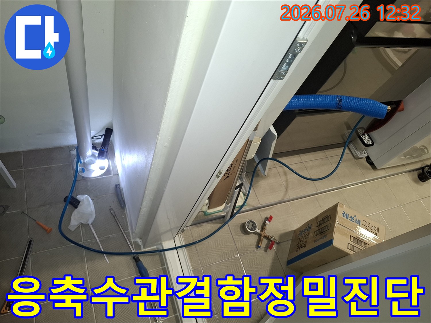파란색 보온재가 감싸진 에어컨 배관과 바닥에 놓인 압력계 및 수공구들