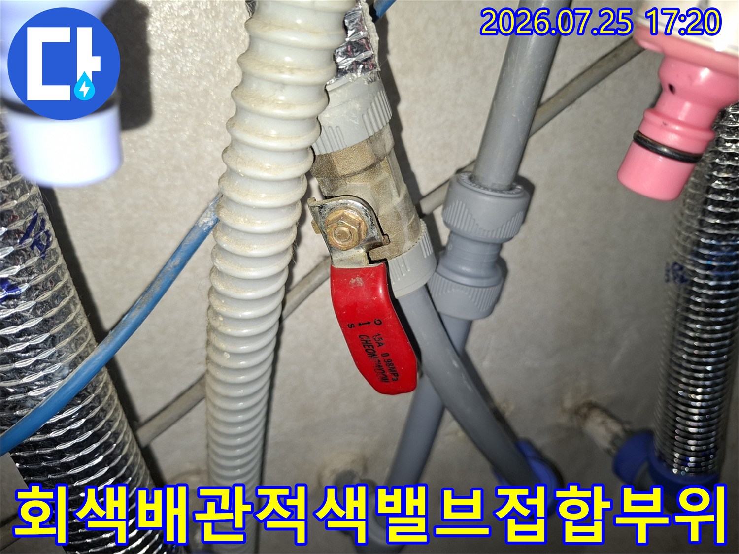 누수가 발생한 적색 밸브와 회색 배관의 연결 부위를 촬영한 사진