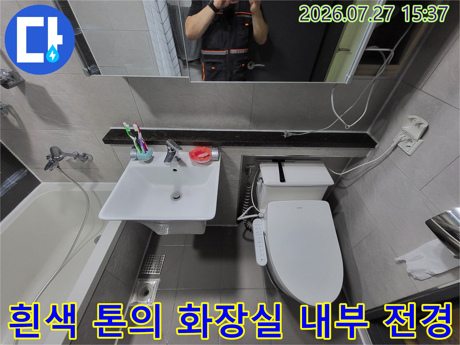 거울과 세면대-변기가 배치된 깨끗한 화장실 인테리어 사진