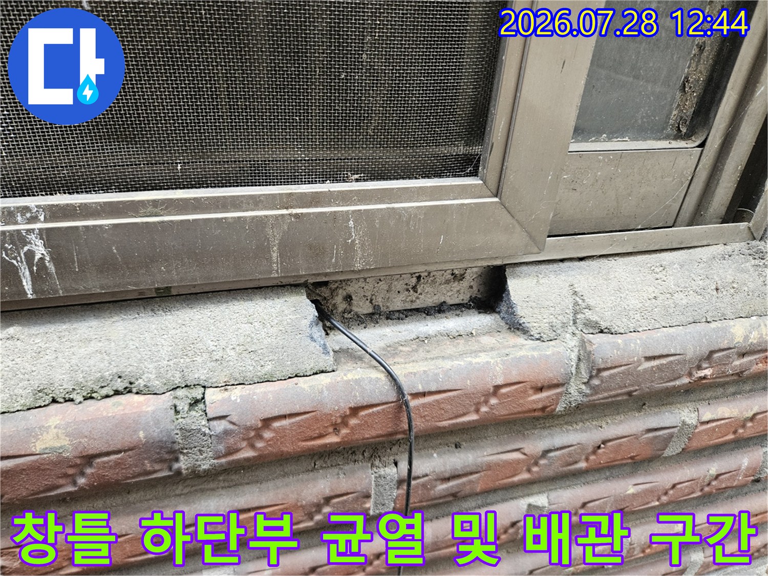 파손된 창문 아래 콘크리트와 노출된 전선 혹은 배관이 섞인 부위