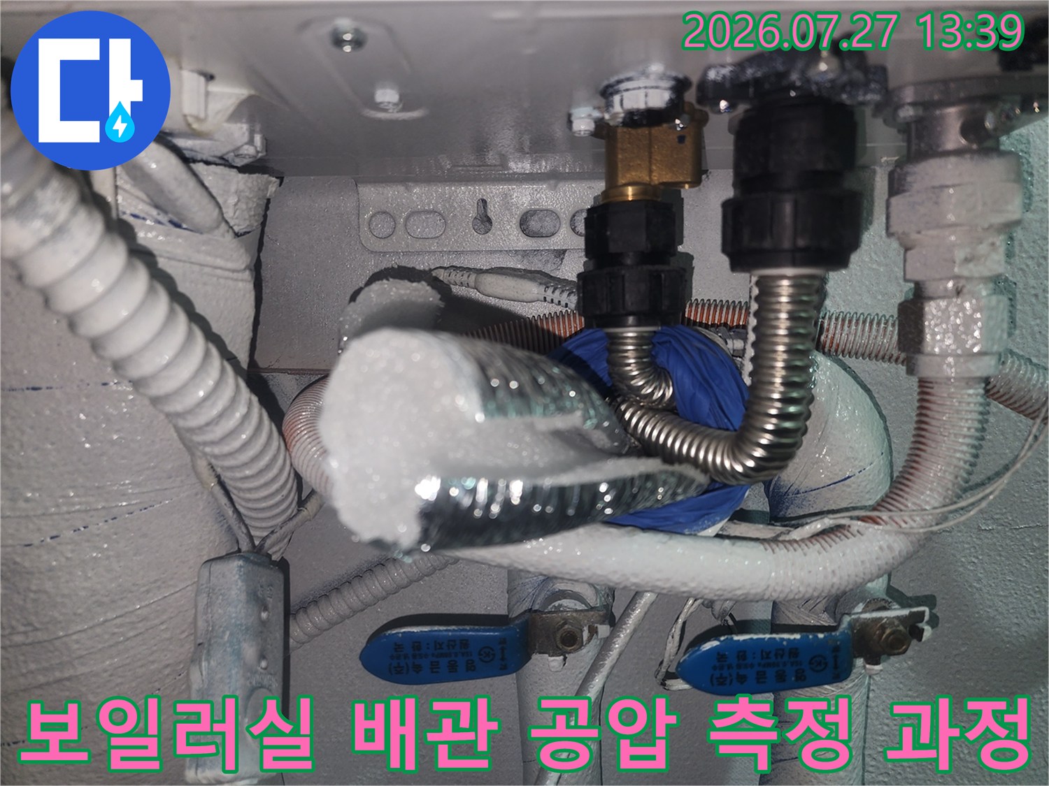흰색 보온재가 씌워진 배관과 검은색 부속-측정 장비가 연결된 상세 모습