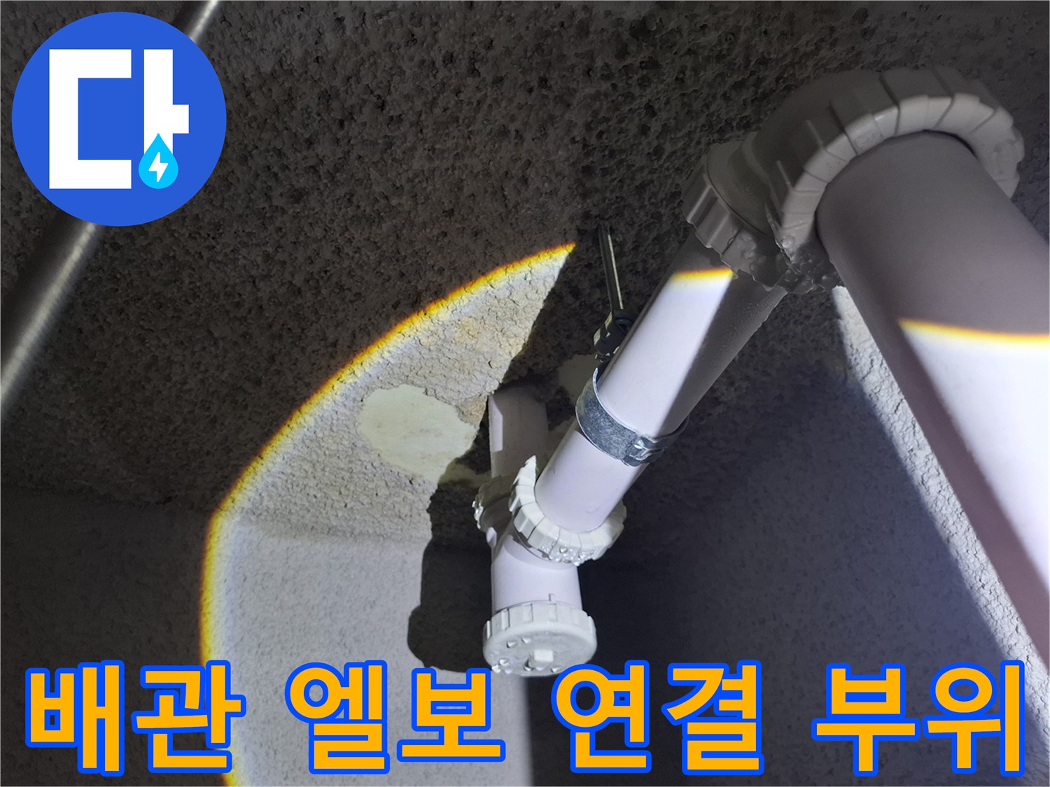 지하 천장에 노출된 하얀색 PVC 배관의 꺾임 부분