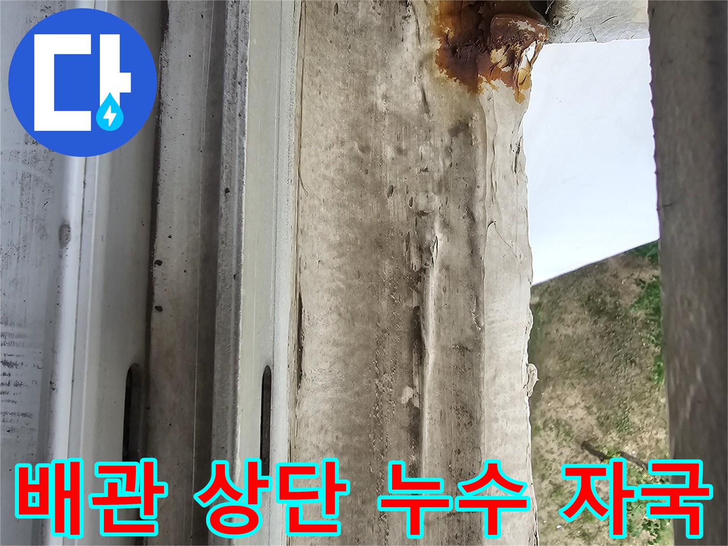 우수관 주변의 녹물 흐른 자국과 젖은 마감재