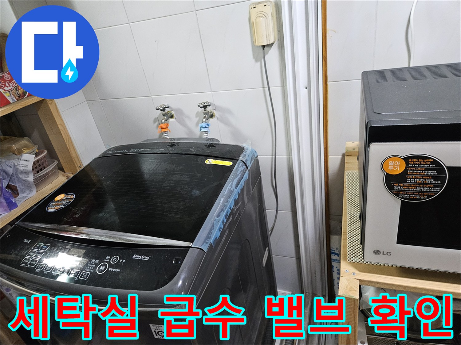 세탁실 벽면의 두 개의 수도꼭지와 세탁기 일부