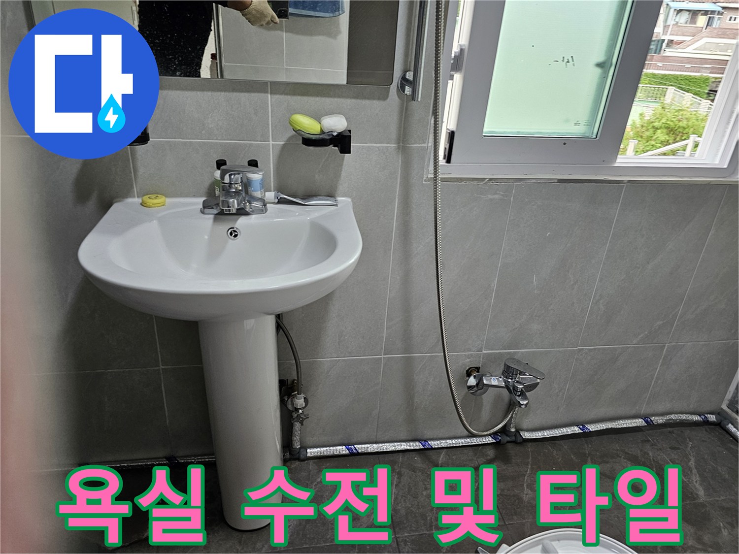 회색-타일-벽면에-설치된-세면대와-샤워기