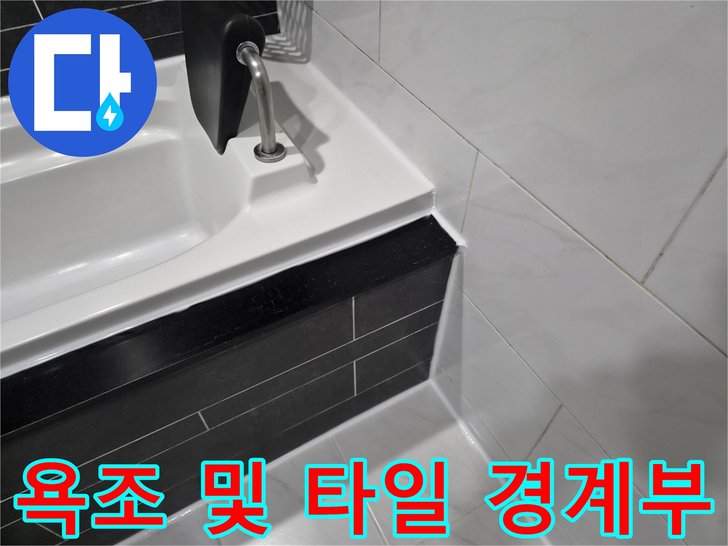 검은색 타일과 하얀색 욕조의 접합 부위