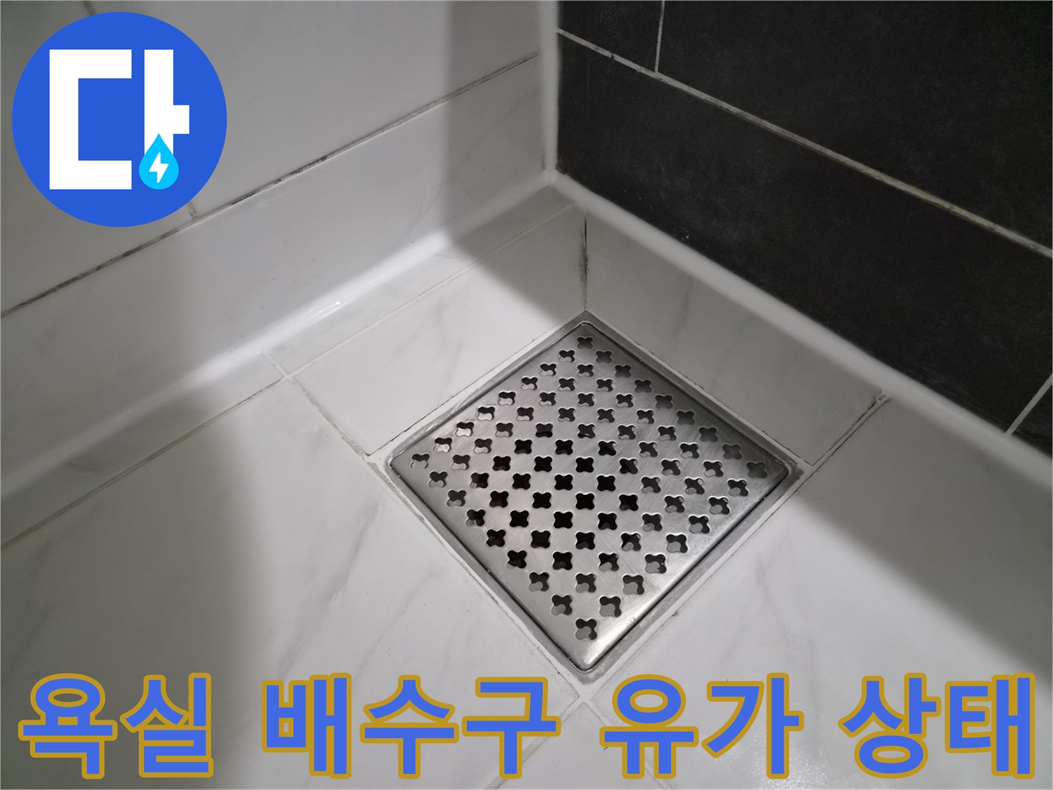 격자형 금속 배수구와 주변 백색 타일