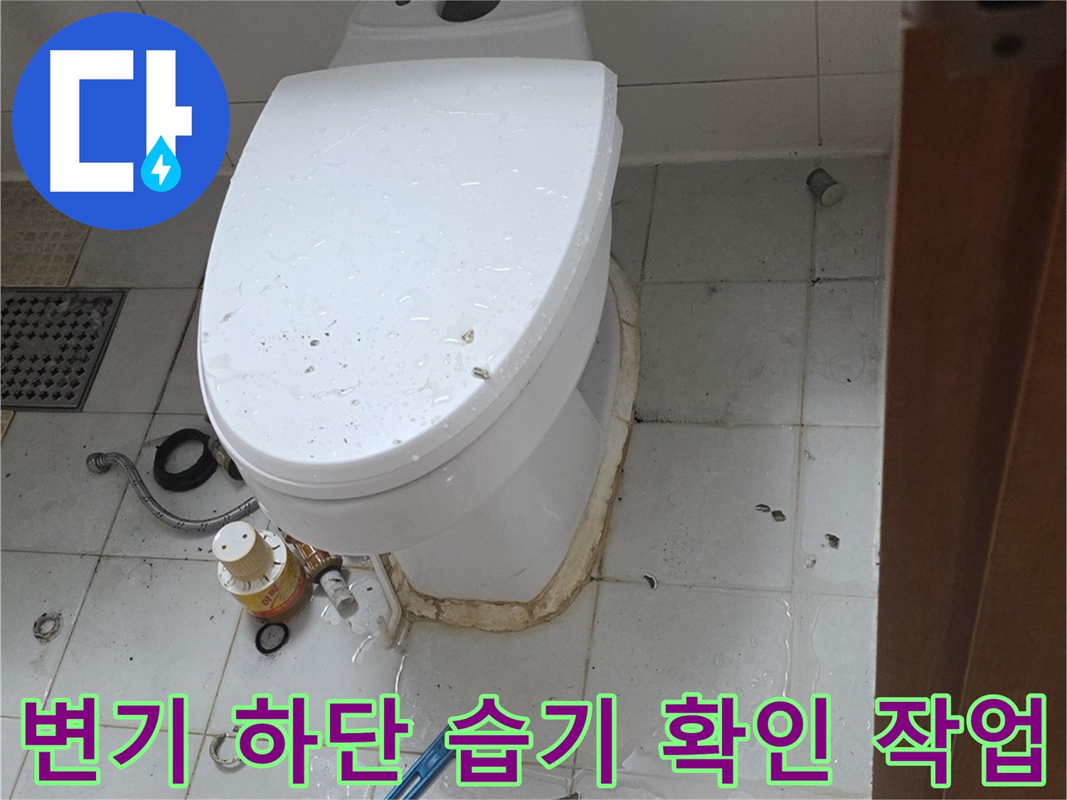 변기 근처 타일 틈새의 물기 참과 누수 수리를 위한 공구 준비 상황