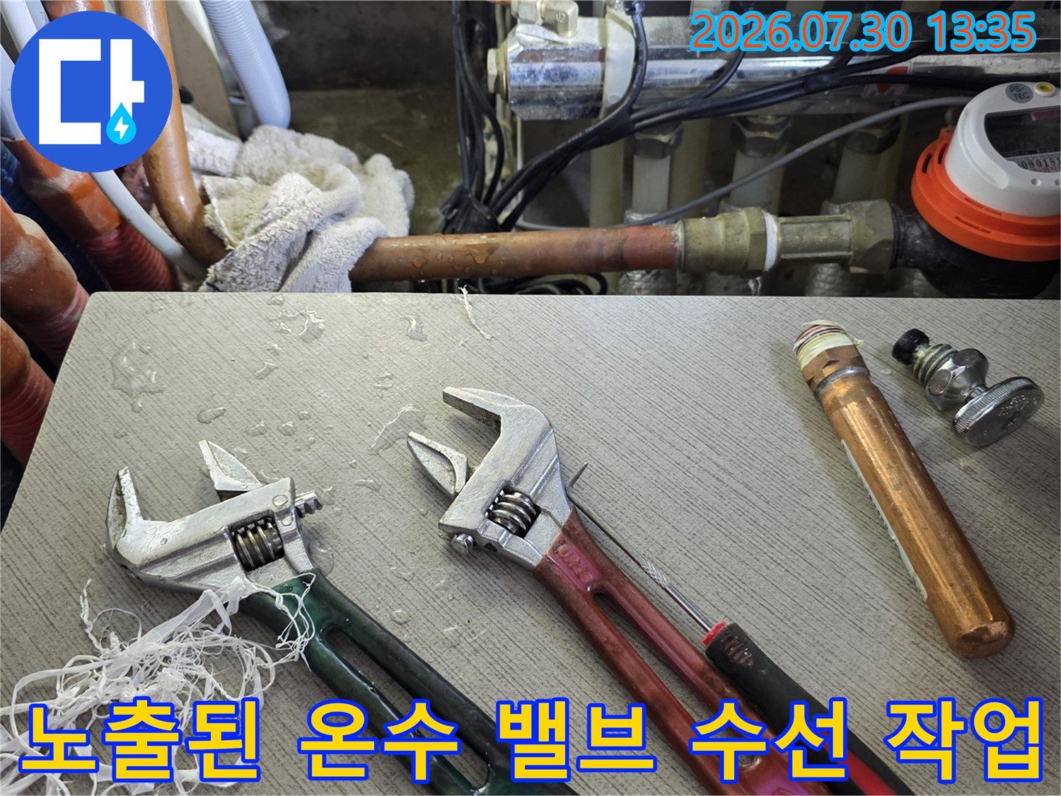 온수 배관 연결 부위와 수리용 렌치 도구들