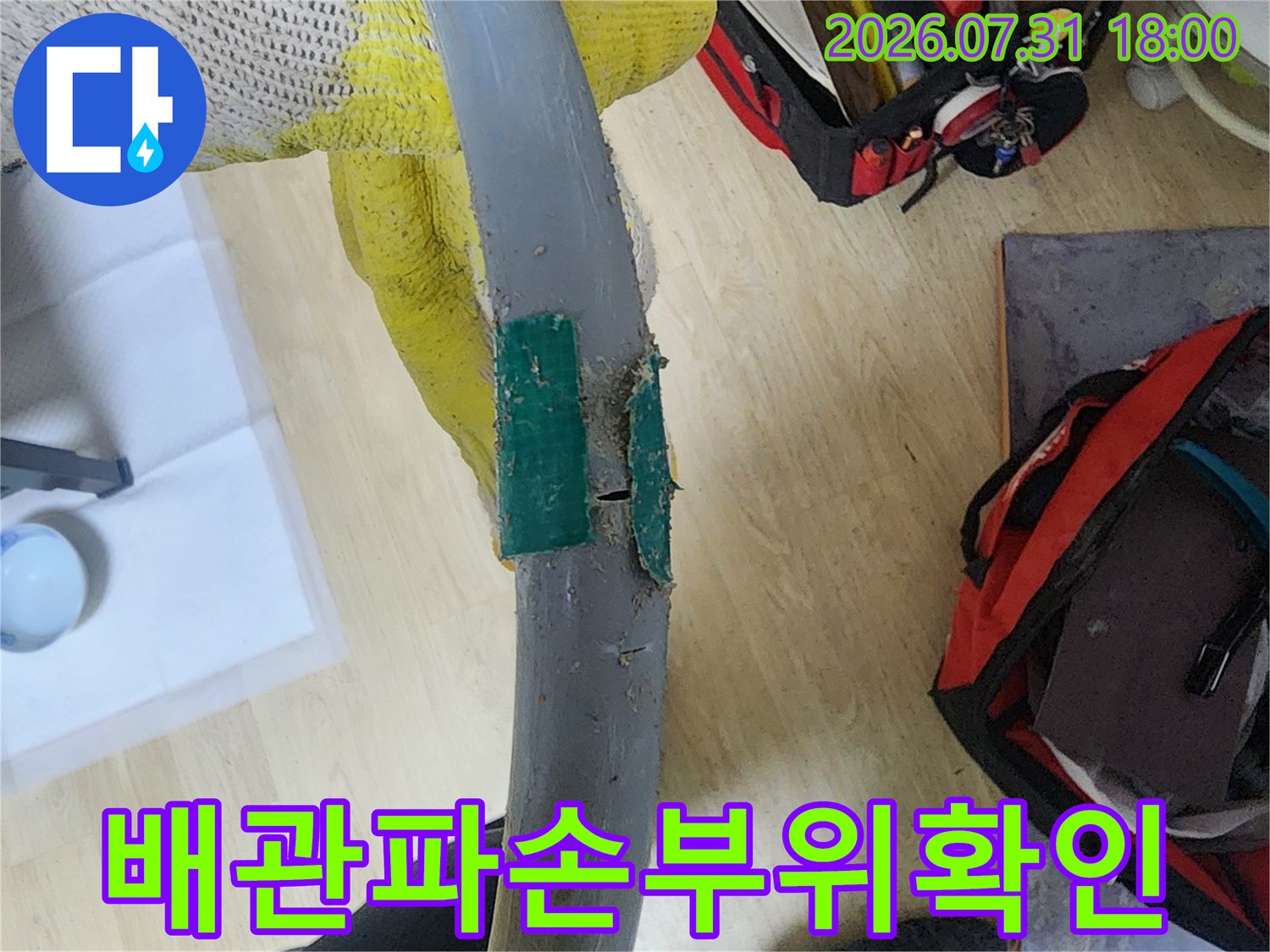 회색 수도배관의 균열 부위를 클로즈업한 사진