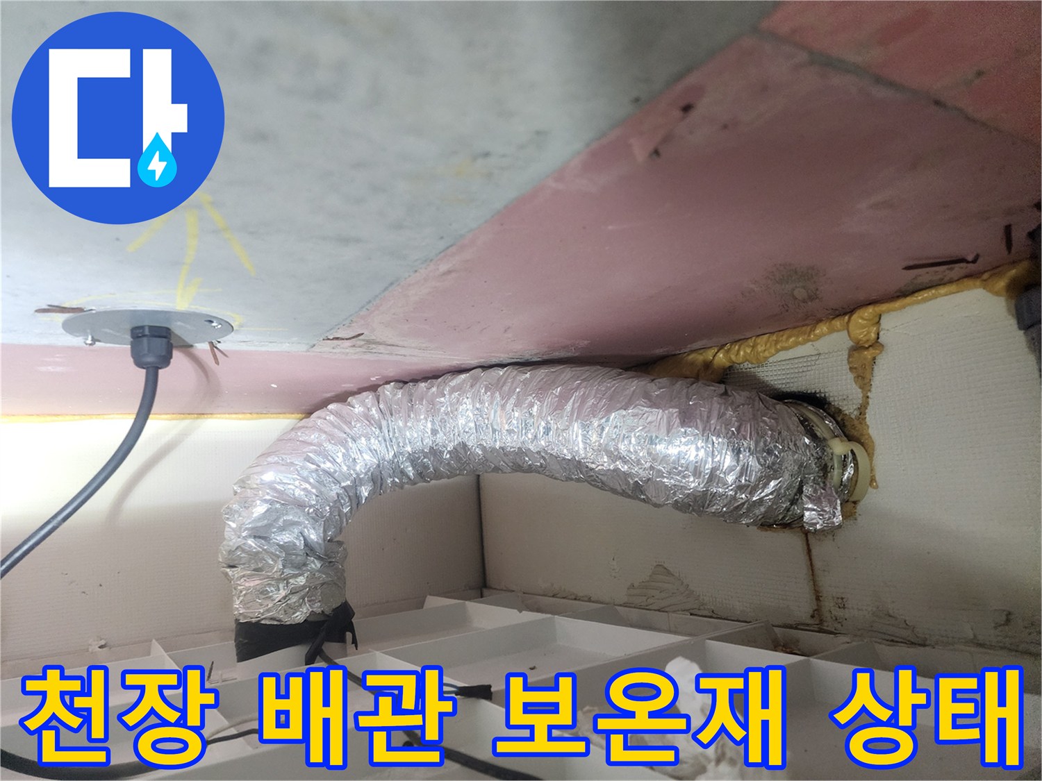 화장실 천장 내부-은색 보온재가 씌워진 배관과 주변 마감재 모습