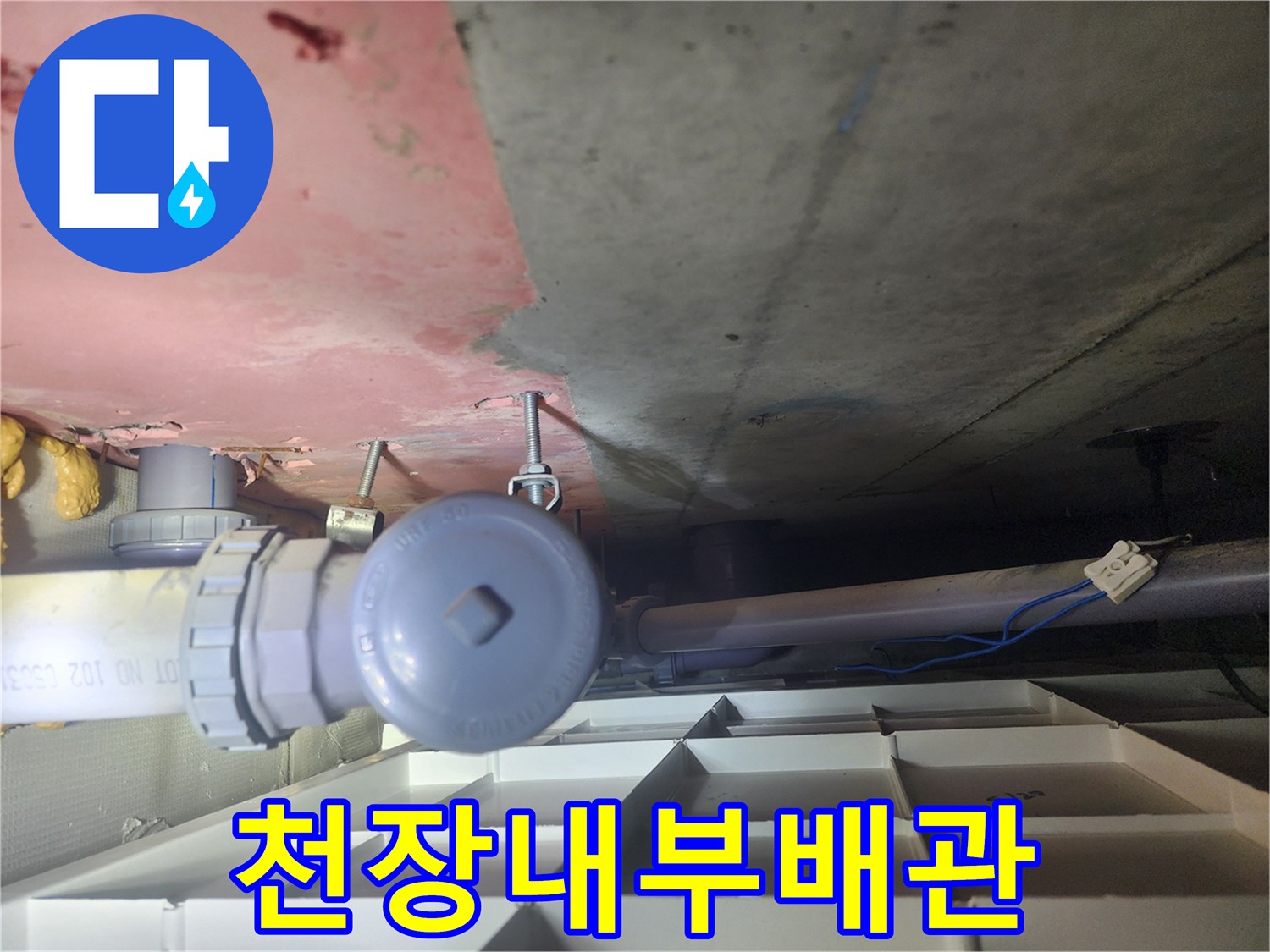 화장실 천장 내부의 배관 연결 부위와 콘크리트 구조물