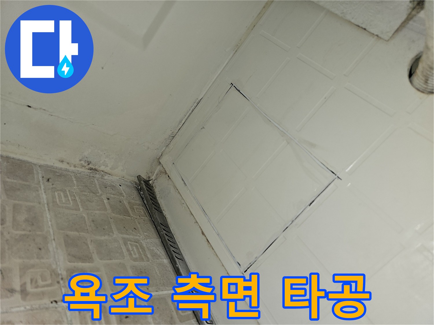 욕조 옆면 타일을 제거하여 내부 배관을 확인하는 현장 사진입니다.