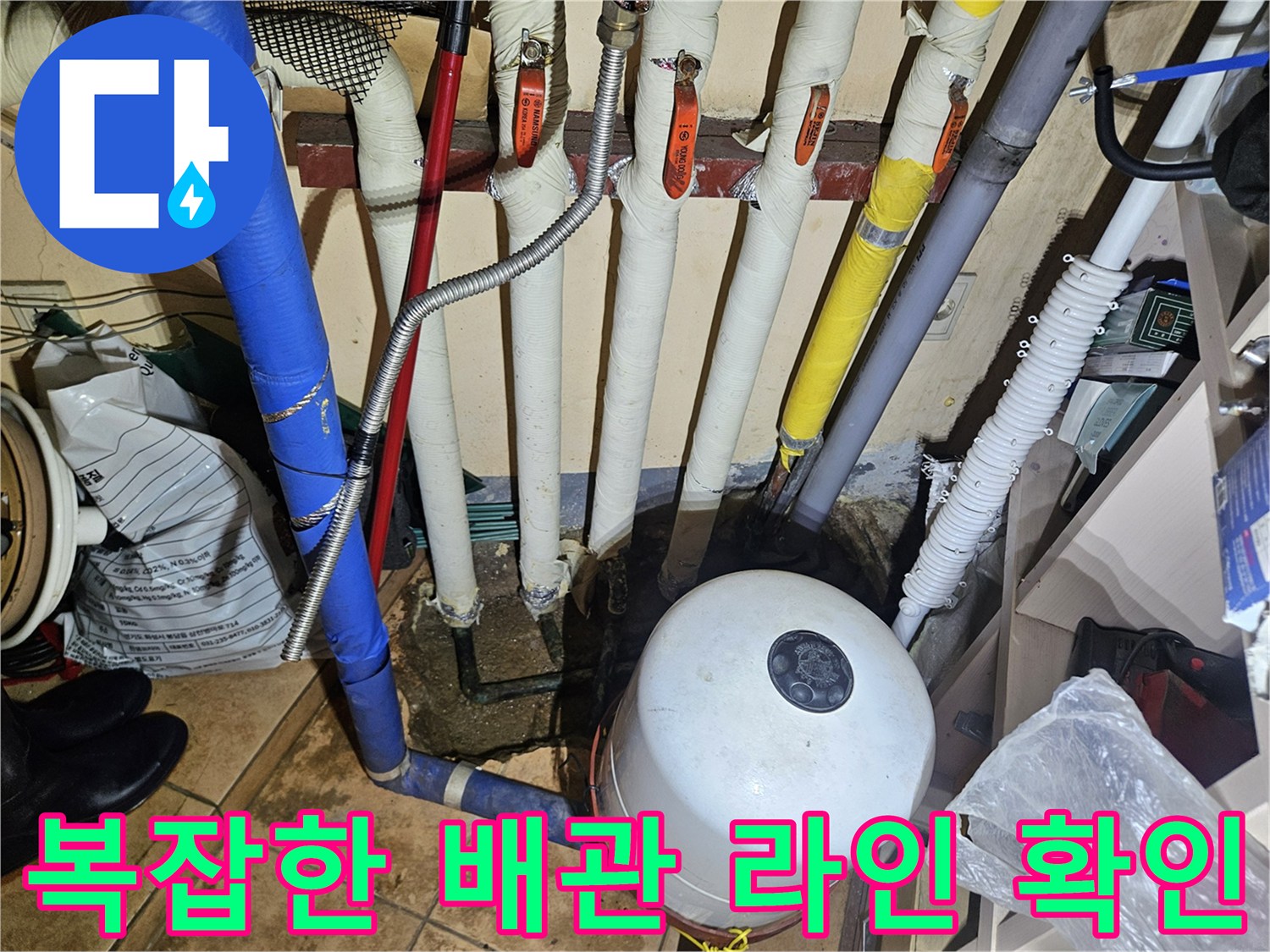 보일러실 내 압력탱크와 보온재가 씌워진 다양한 규격의 배관들