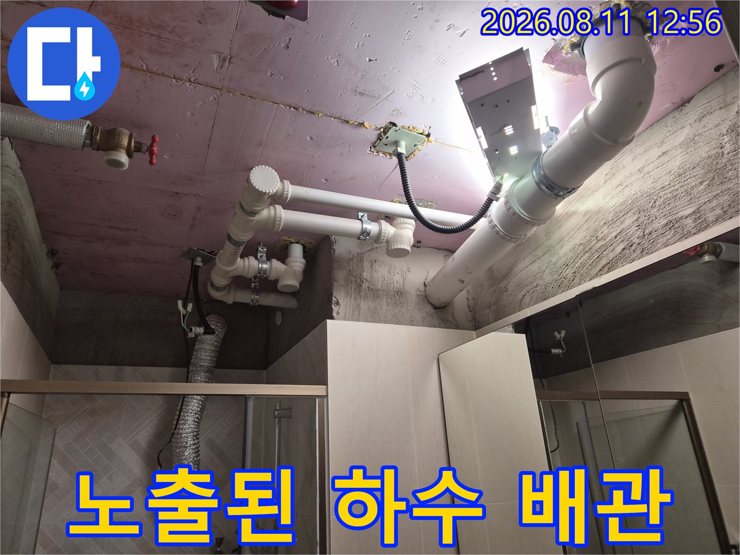 분홍색 천장 슬라브에 설치된 흰색 PVC 배관 구조물