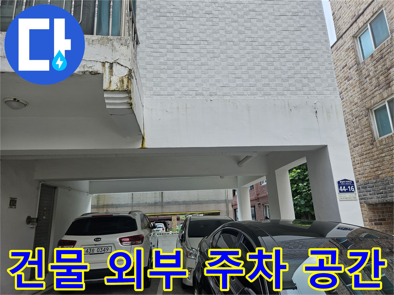 하얀색 차량이 주차된 필로티 건물 내부 전경