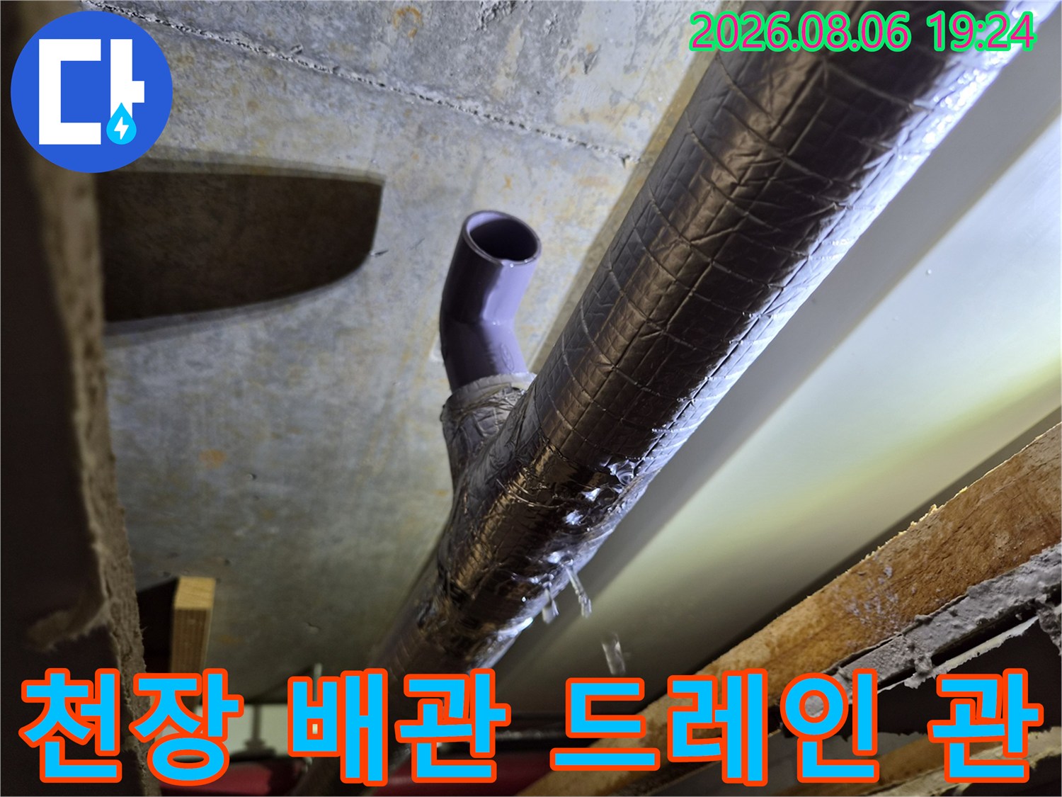 보온재로 마감된 배관과 돌출된 보라색 에어컨 배수관의 연결 지점