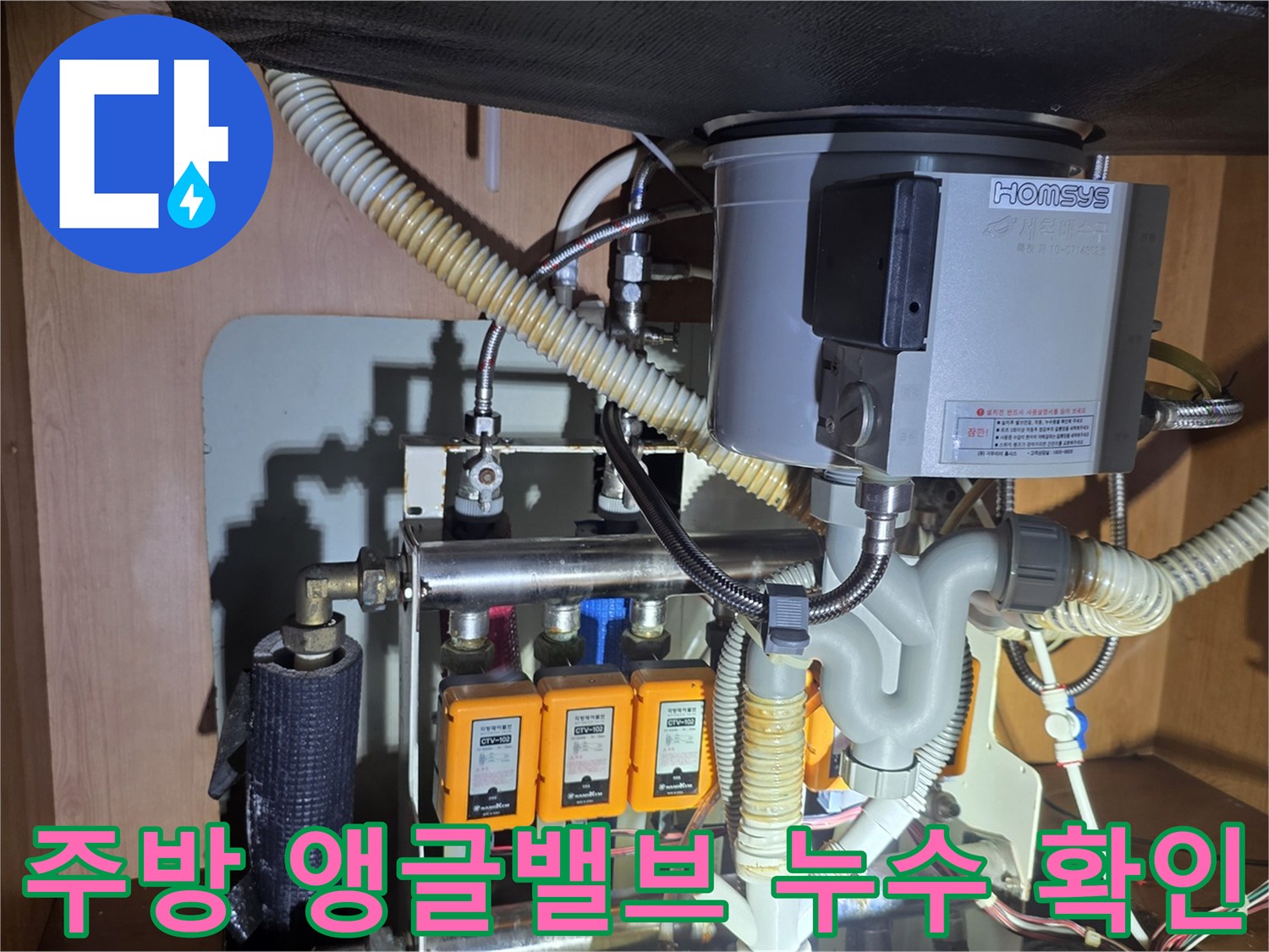 싱크대 하부장 내부의 앵글밸브 및 연결 호스 모습