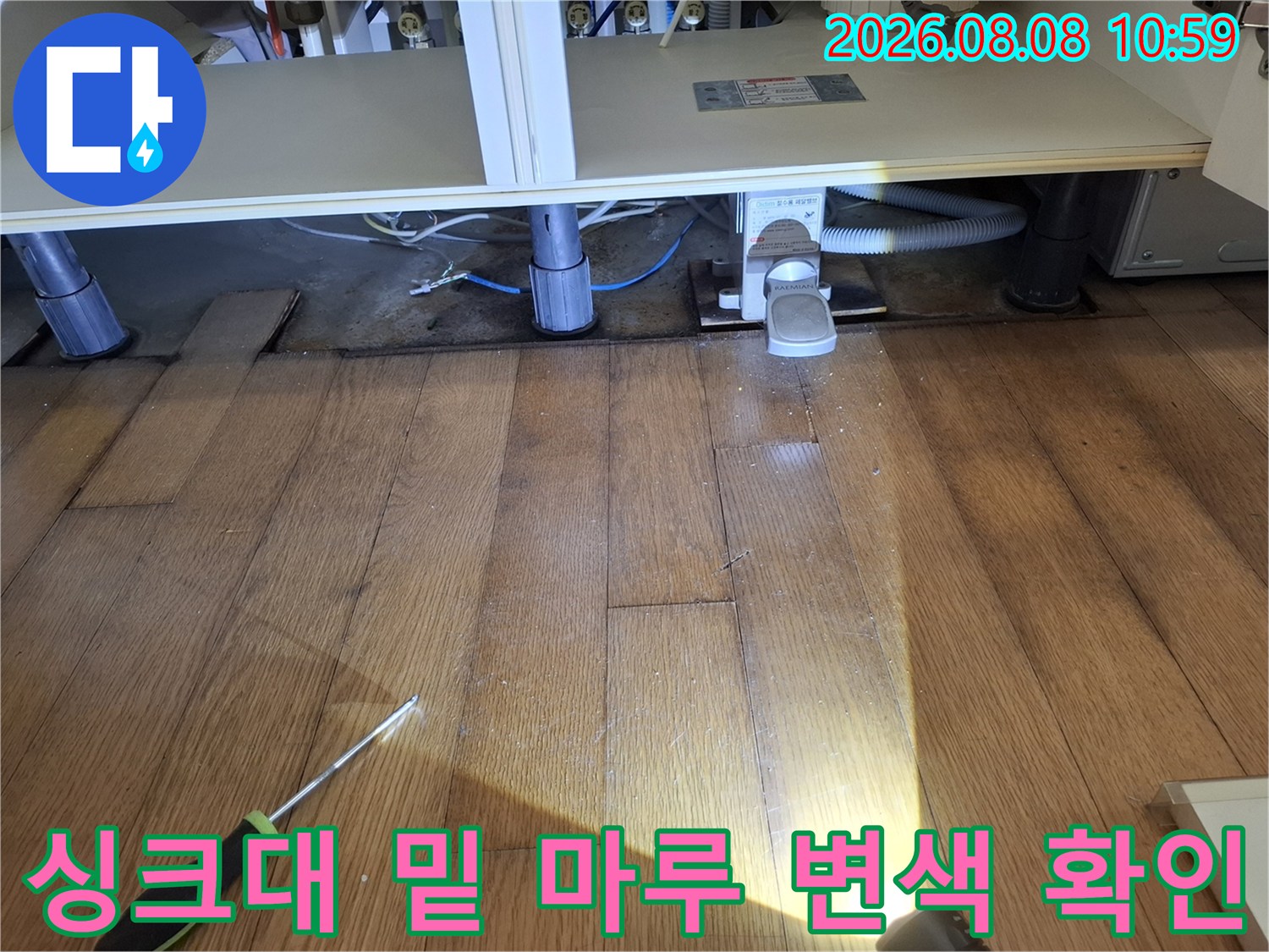 싱크대 아래 배관 주변-변색된 마루를 통해 누수 흔적을 조사하고 있습니다