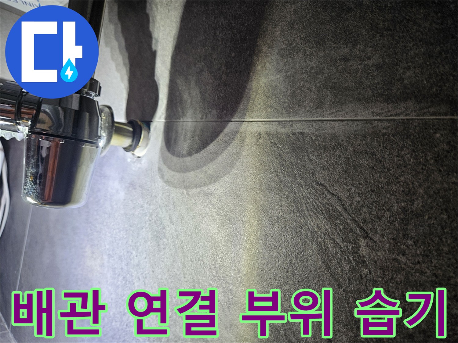 어두운 색상의 타일과 은색 배관 부품의 근접 사진