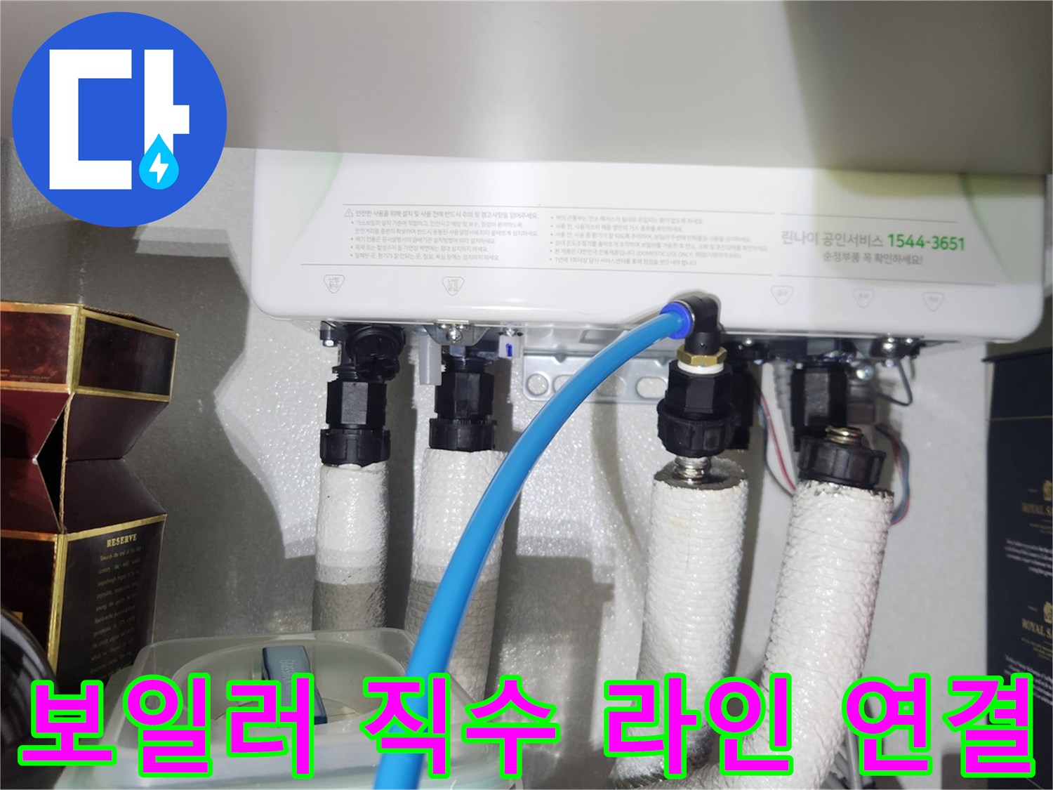 파란색 호스가 연결된 보일러 하단 배관 부위