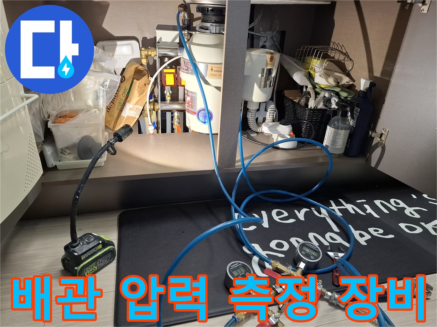 누수 진단을 위해 배관에 연결된 압력 게이지와 파란색 호스