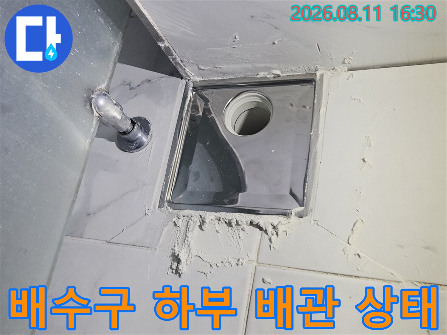천장 점검구 내부의 배수 배관 연결 부위와 주변 마감재의 습기 상태를 촬영한 사진입니다.