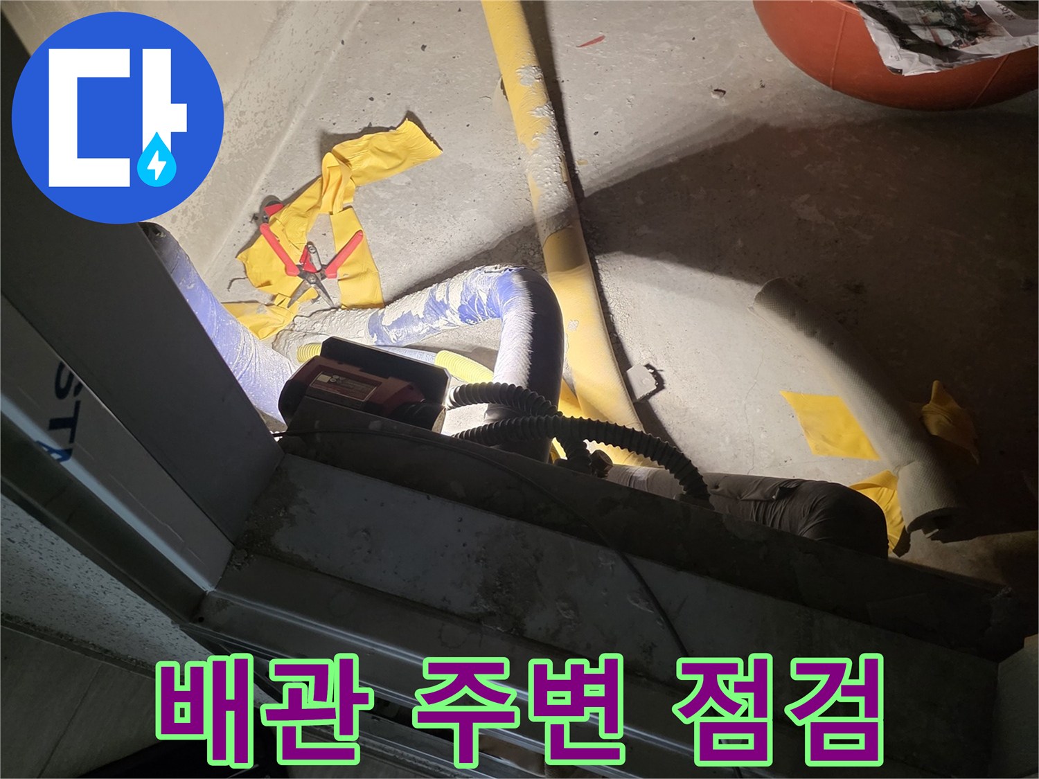 점검구 내부의 노출된 배관과 보수용 자재들