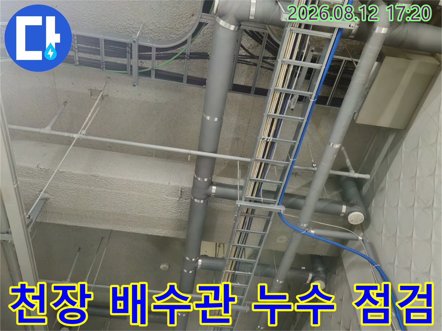 지하 주차장 천장에 설치된 대형 배수관과 전기 트레이의 상세 모습