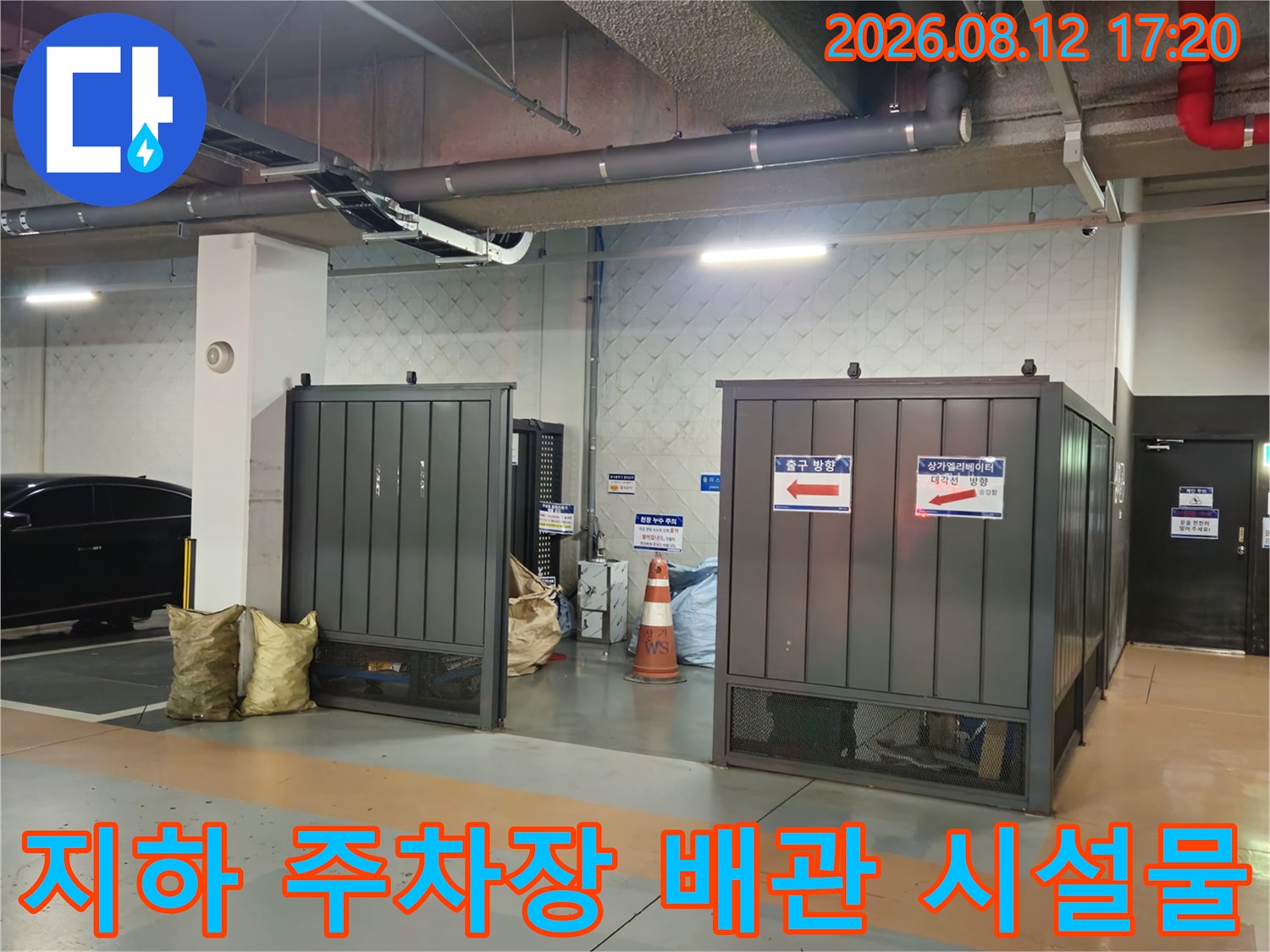 지하 주차장 천장에 설치된 은색 배관과 전기 트레이 전경