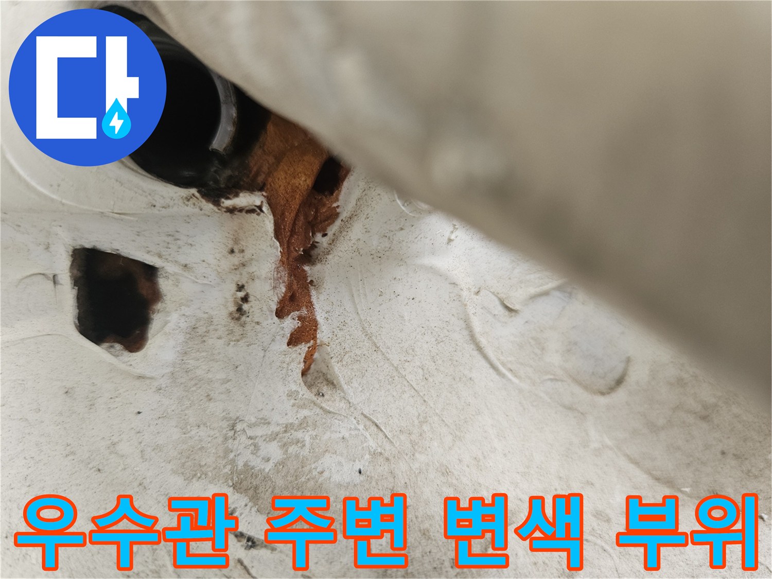 우수관 배관 하단의 젖은 벽면과 갈색 얼룩 현상
