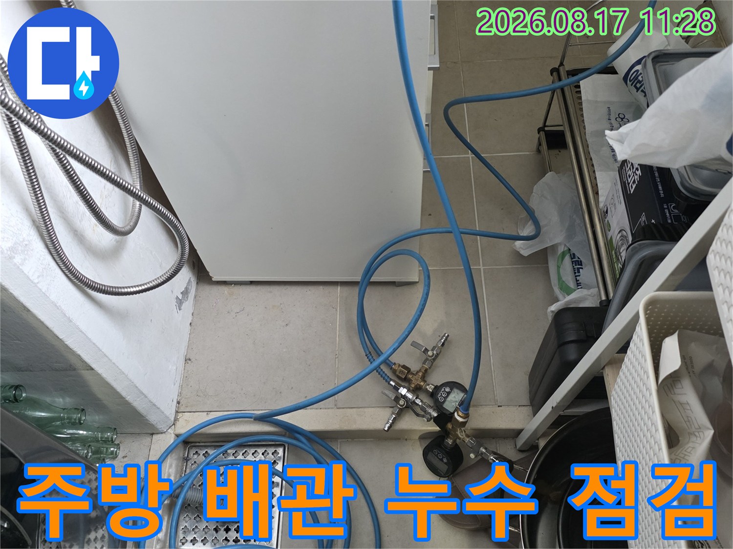 싱크대 하부의 배수구와 압력 측정을 위해 연결된 파란 호스