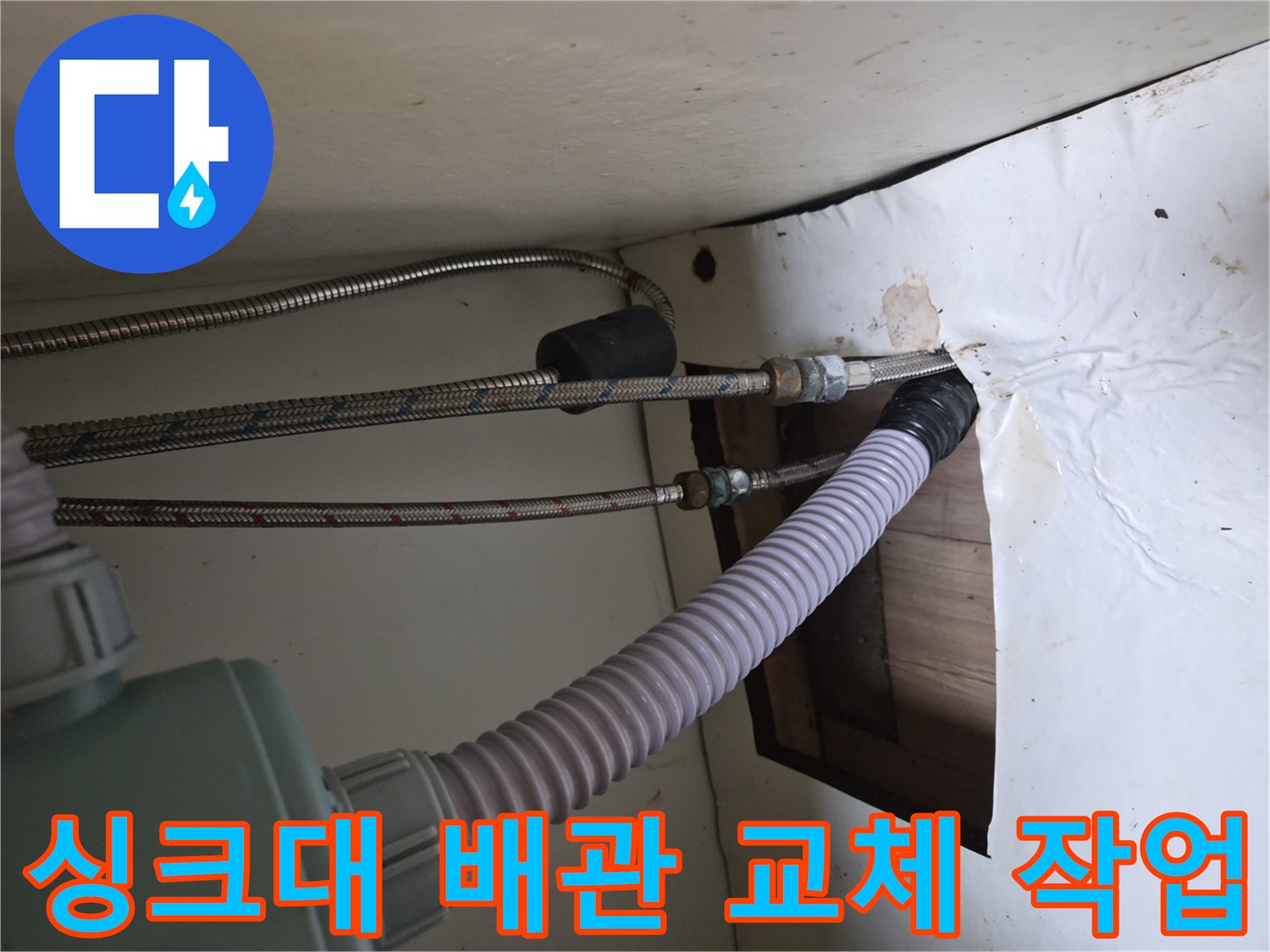 싱크대 하부장 내부의 노후된 고압 호스와 배수 호스 상태