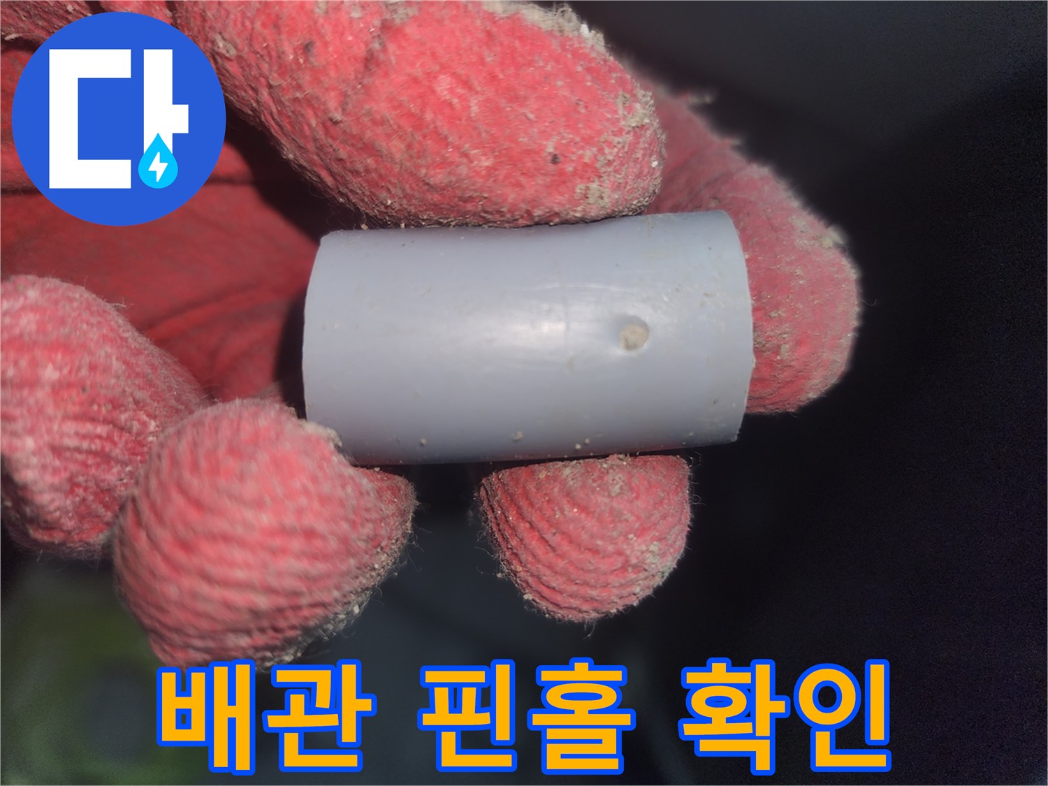 작업자가 손에 든-구멍 난 배관 조각