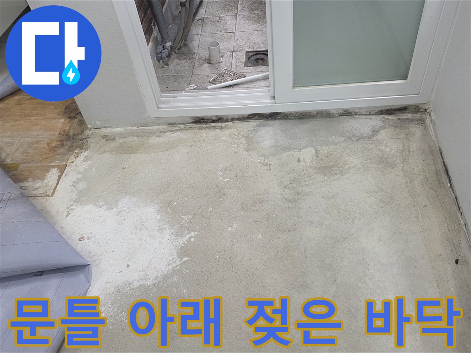 욕실 문틀 하단부의 타일 오염 및 습기 침투 상태