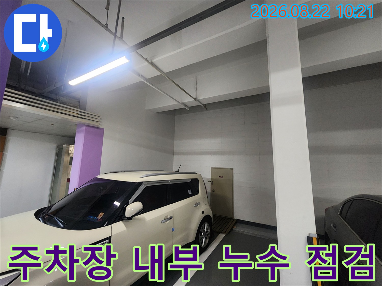 흰색 차량이 주차된 지하주차장의 천장 구조물 모습입니다.