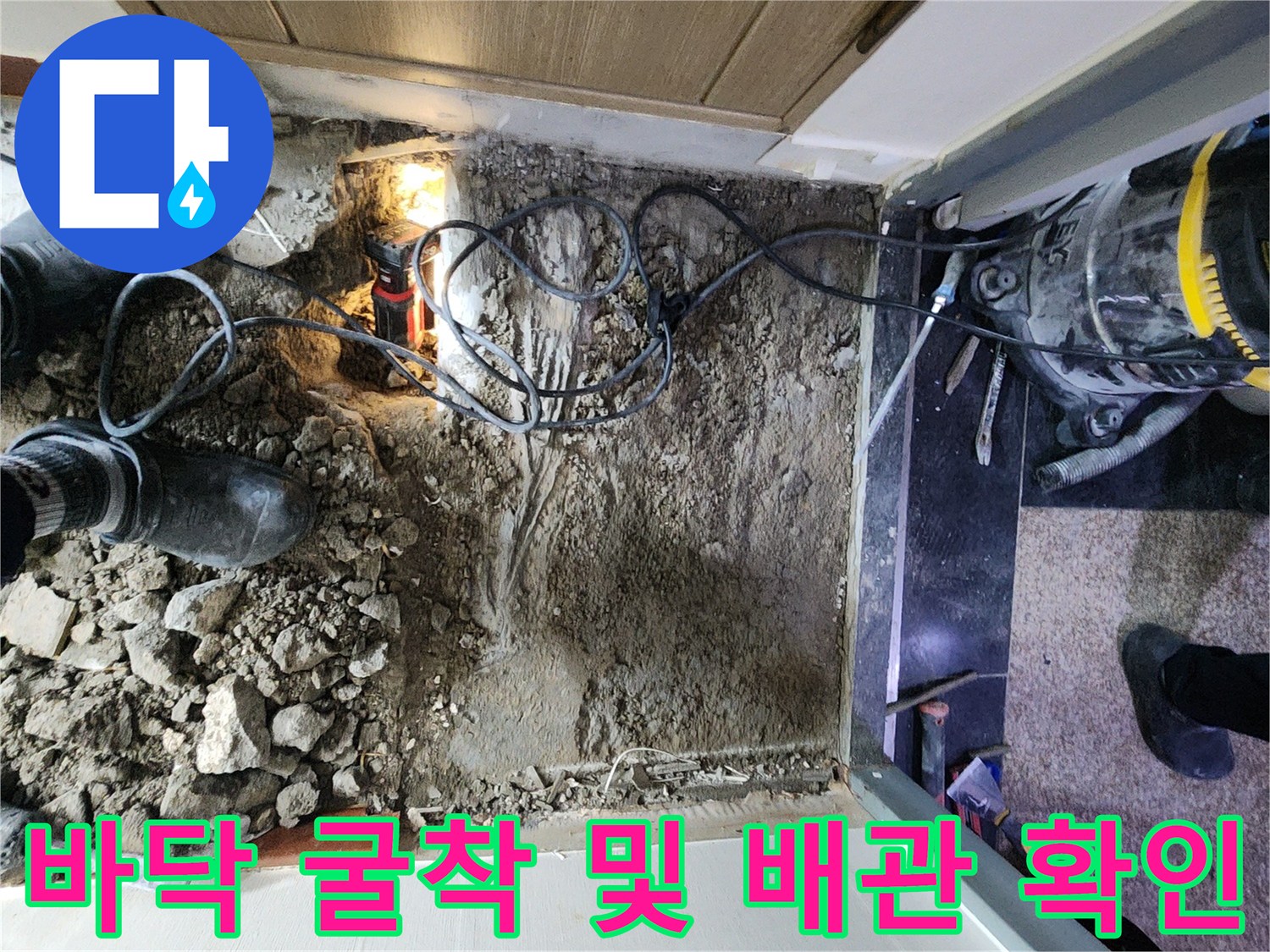 공사 중인 화장실 바닥의 파쇄된 콘크리트와 작업 장비