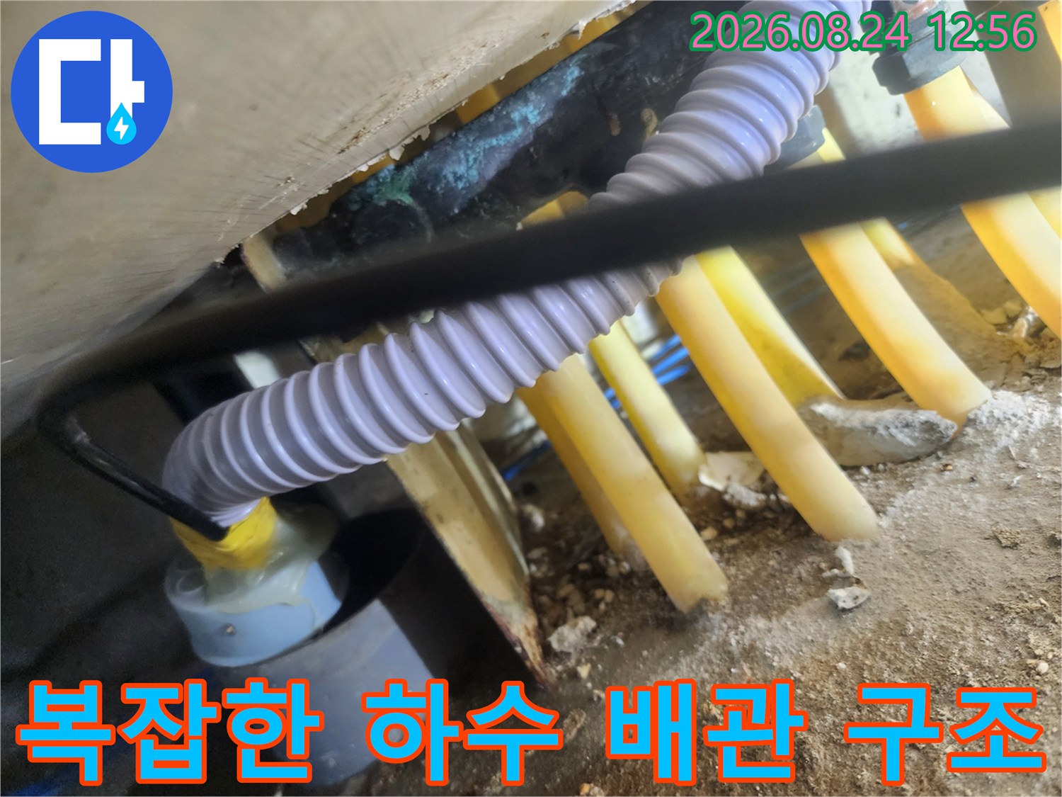 노란색 하수 배관과 흰색 주름 호스가 연결된 모습