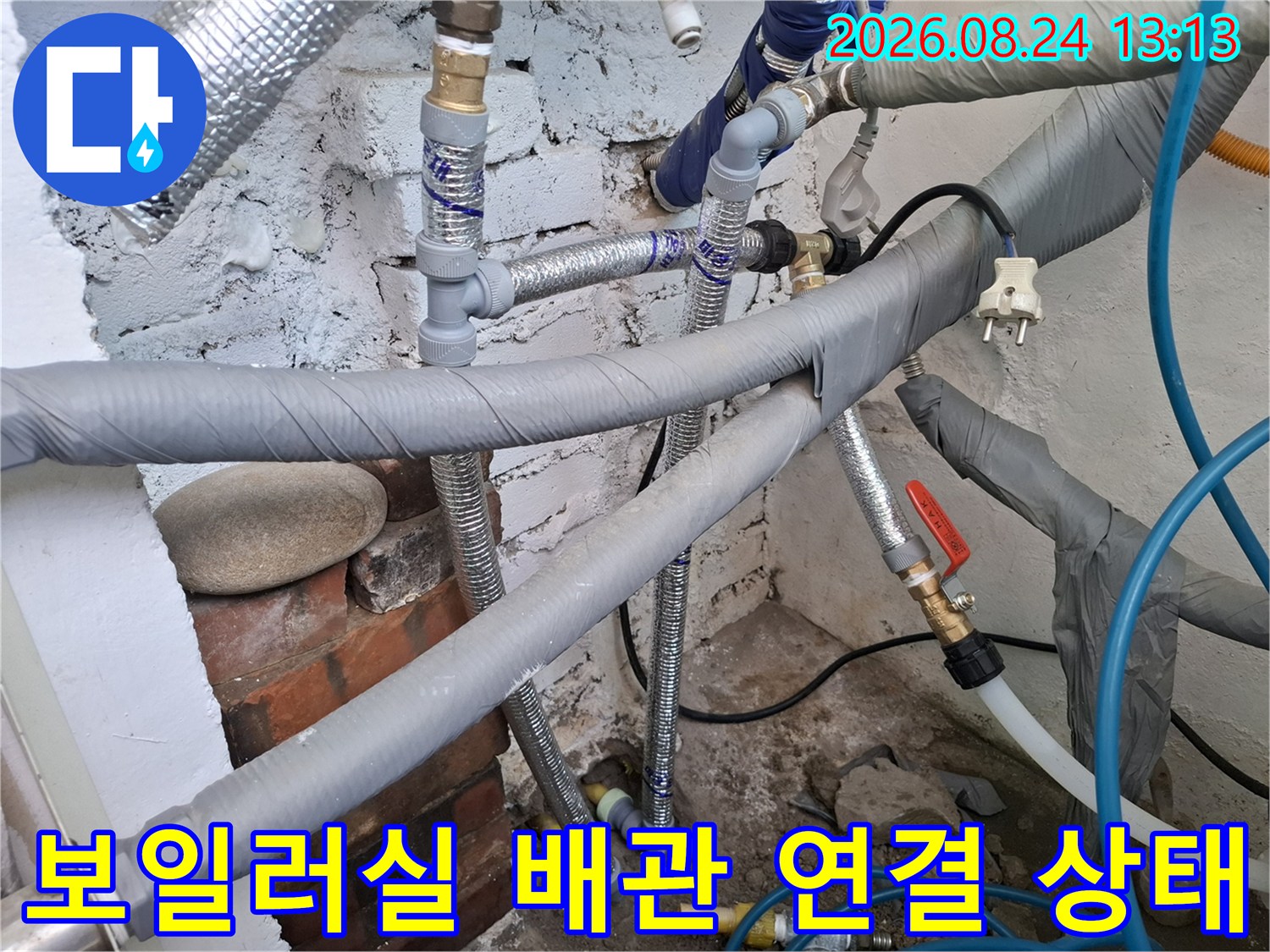 은색 보온재와 파란색 호스가 복잡하게 설치된 보일러실 내부