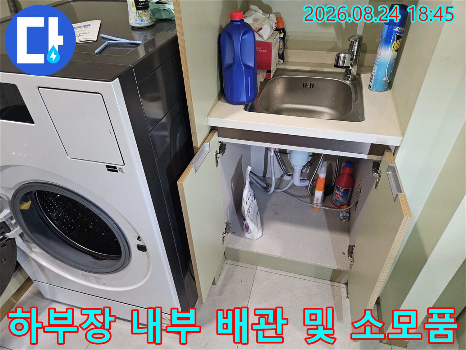 세탁실 하부장의 배수 배관과 세제들