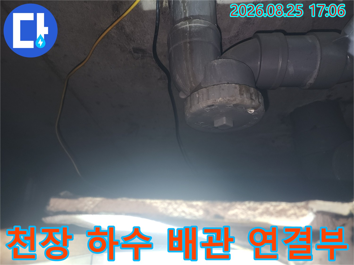 아파트 천장에 설치된 회색 하수 배관과 부속품 상세 모습