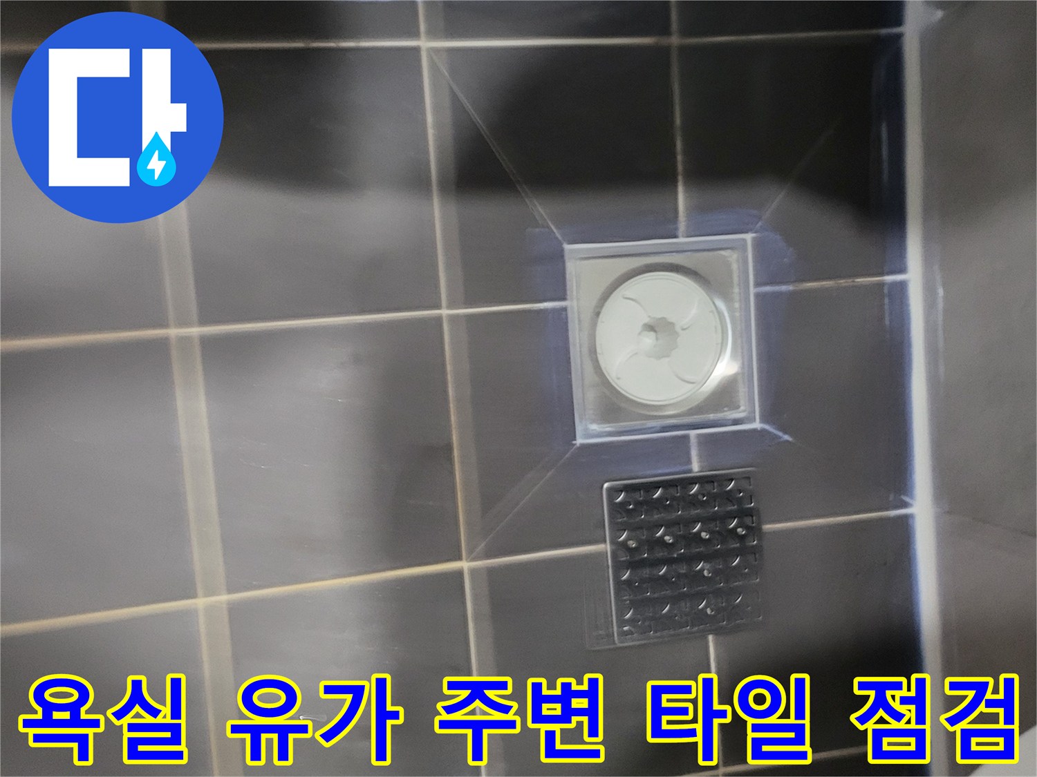 어두운 회색 타일과 하얀색 배수 트랩 부근