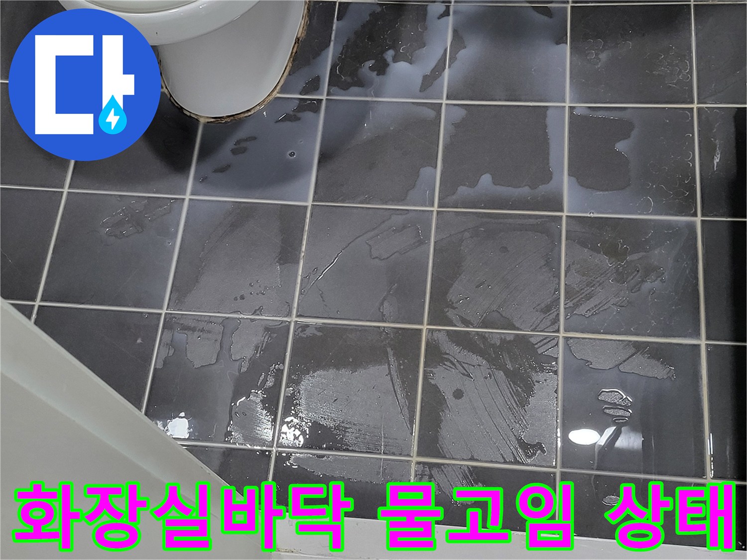 어두운색 타일 위에 물이 흥건하게 고여 있는 모습