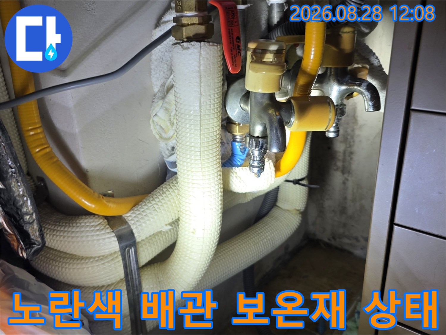 보온재로 감싸진 노란색 배관과 금속 밸브의 연결 부위 상세 사진
