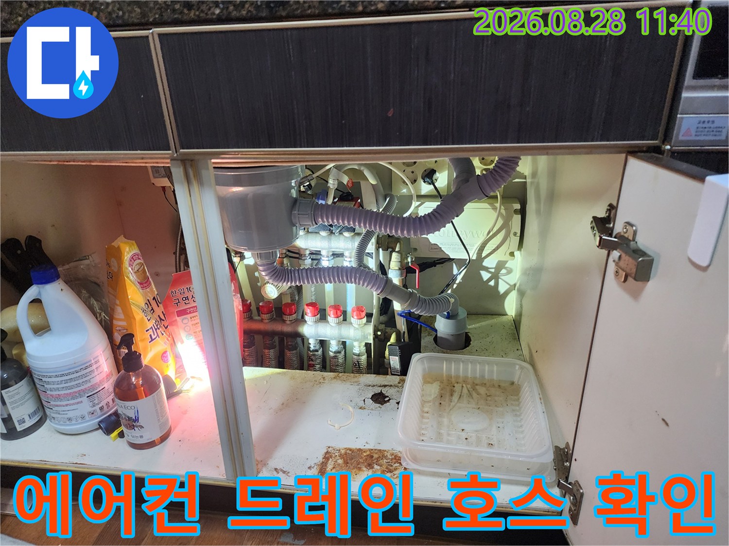 싱크대 아래쪽 에어컨 배수 호스와 연결된 다중 배관 구조