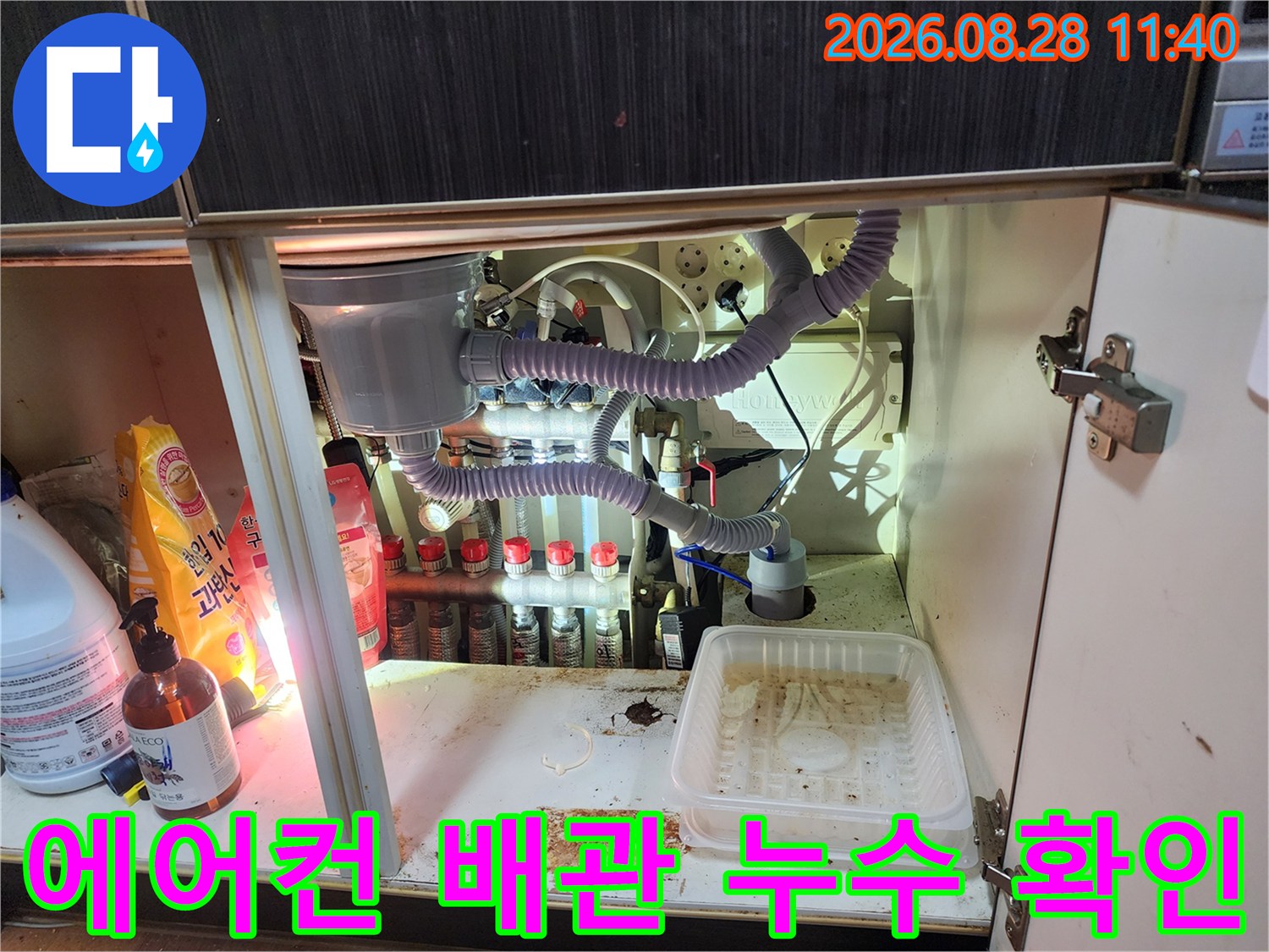 싱크대 아래쪽의 복잡한 정수기 필터와 에어컨 드레인 호스