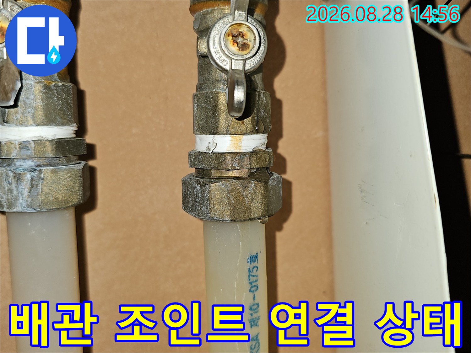 금속 밸브와 하얀색 배관이 결합된 연결 부위 상세 사진