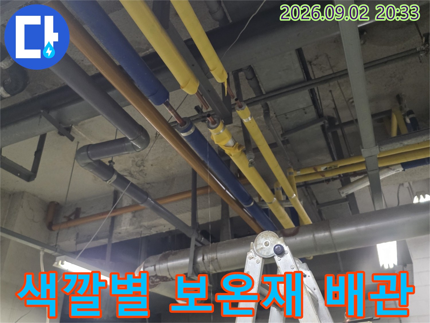 천장 구조물 내부-보온재로 마감된 노란색과 파쉽색 배관 설비